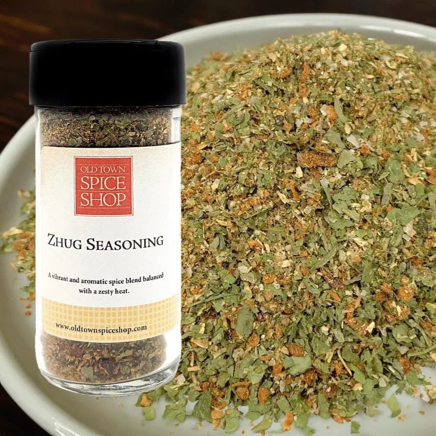 Jar of Zhug Seasoning from Old Town Spice Shop with a pile of the seasoning on a plate.