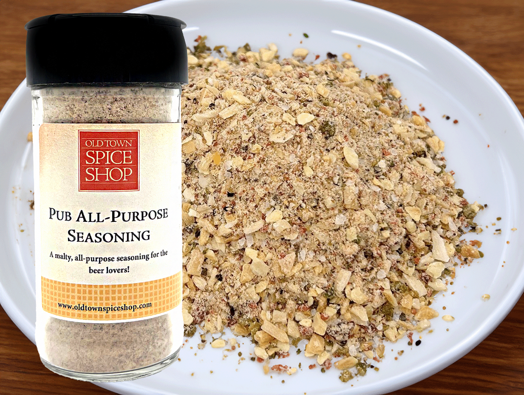 Bottle of Old Town Spice Shop Pub All-Purpose Seasoning next to a plate of mixed herbs and spices.