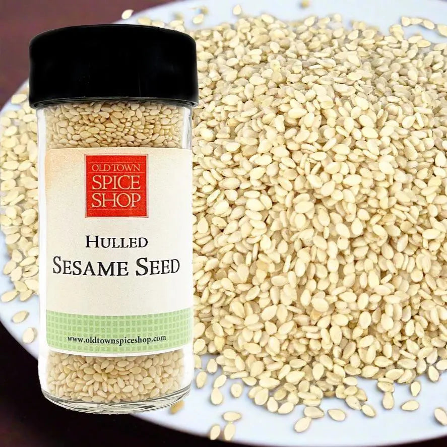 Jar of hulled sesame seeds from Old Town Spice Shop on a plate with sesame seeds.