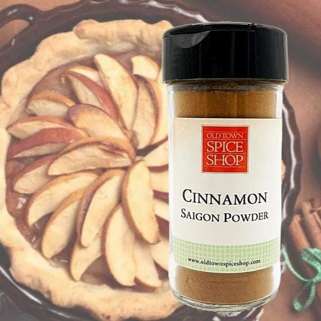 Bottle of Old Town Spice Shop Cinnamon Saigon Powder with an apple pie in the background