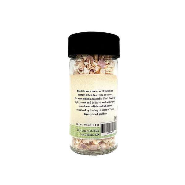 Jar of freeze-dried shalots with a black lid on a white background
