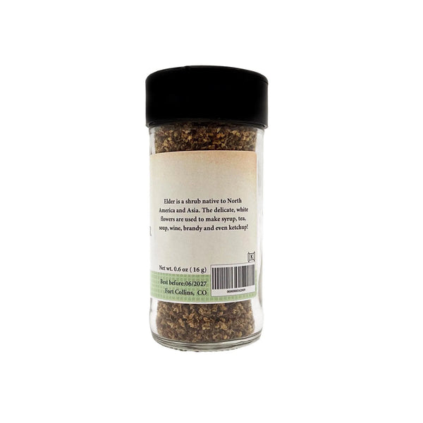 Glass jar of herbs with a black lid on a white background