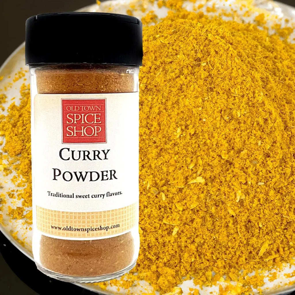 Jar of Old Town Spice Shop Curry Powder with curry powder on a plate in the background