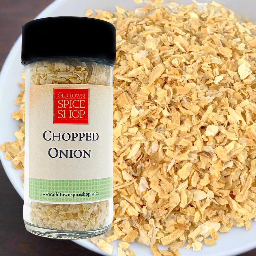 Bottle of Old Town Spice Shop chopped onion seasoning with a plate of chopped onions in the background.