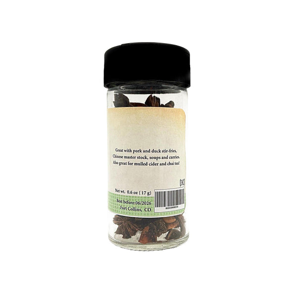 Jar of dried herbs with a black lid on a white background