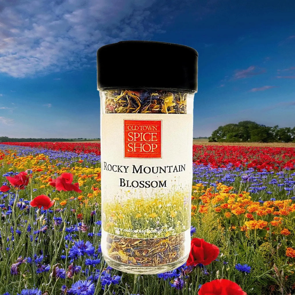 Bottle of Old Town Spice Shop Rocky Mountain Blossom spice blend with a colorful flower field in the background