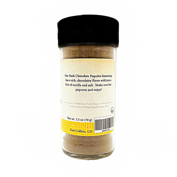 Glass container of dark chocolate popcorn seasoning with a black lid on a white background