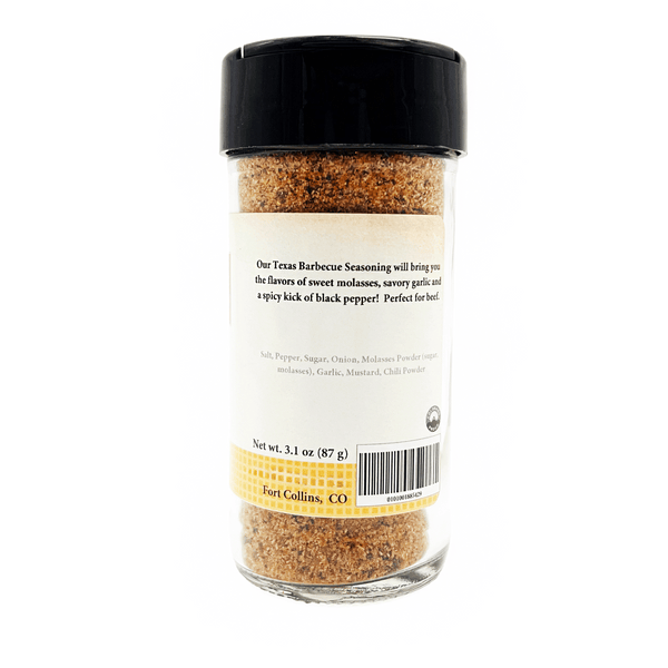 A clear plastic bottle of Texas Barbecue Seasoning with a black lid and a white label, showing the back side of the packaging with product details and a barcode.