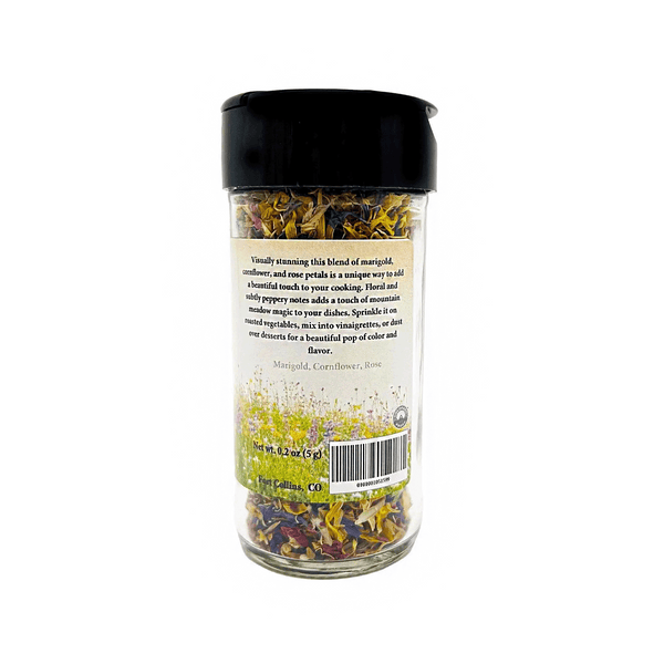 Glass jar with black lid containing dried herbs on a white background
