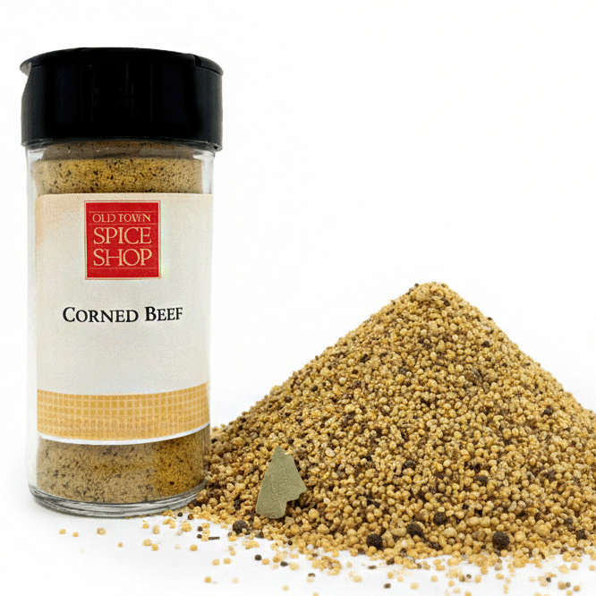 Spice jar labeled 'Corned Beef' from Old Town Spice Shop with spilled spice on a white background