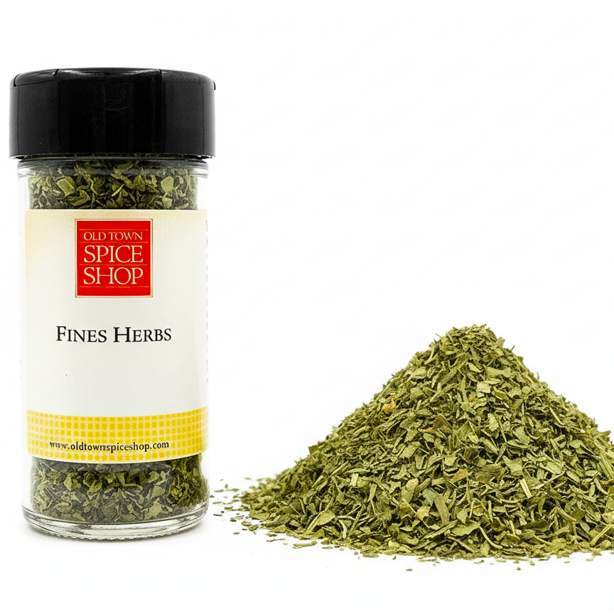Jar of Old Town Spice Shop Fines Herbs with a pile of herbs on a white background
