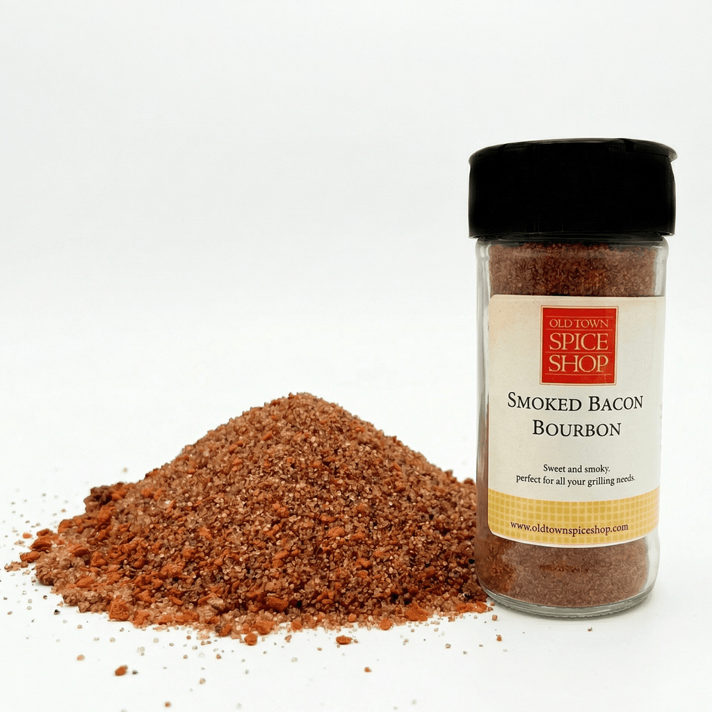 Spice jar labeled 'Smoked Bacon Bourbon' from Old Town Spice Shop with spilled spice on a white background