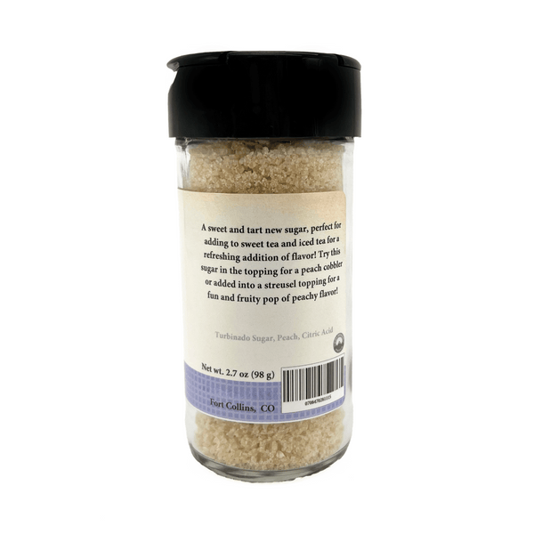 Glass container of sugar with a black lid on a white background