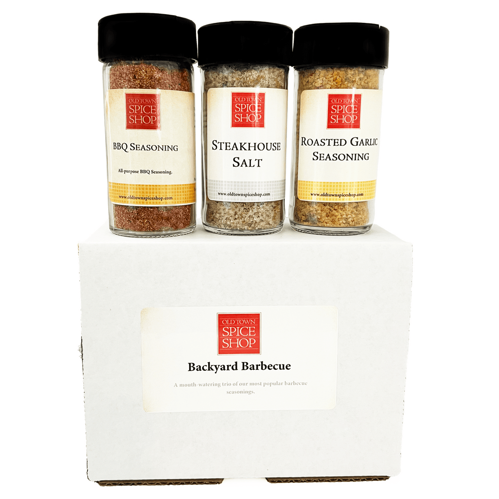 A white gift box labeled 'Backyard Barbecue' from Old Town Spice Shop, with three spice jars on top: BBQ Seasoning, Steakhouse Salt, and Roasted Garlic Seasoning.