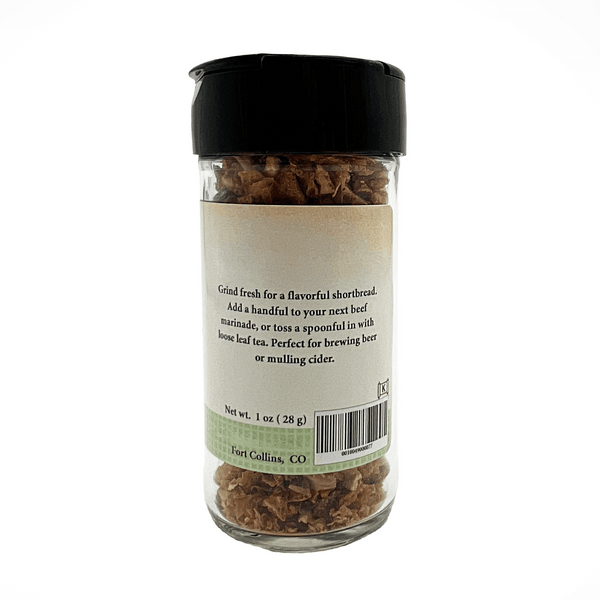 Glass jar with black lid containing dried herbs or spices