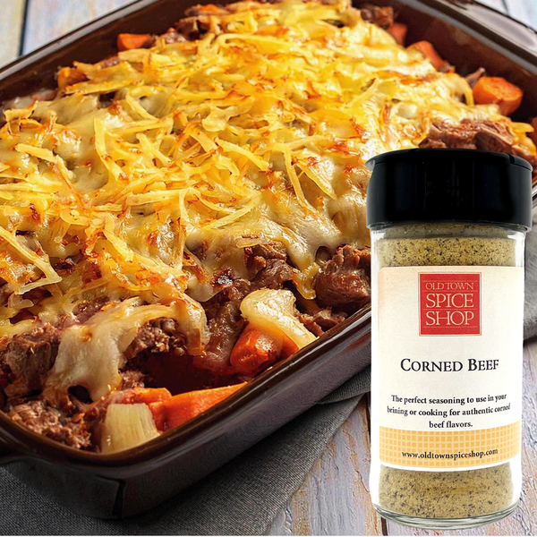 Baked dish with corned beef and carrots next to a bottle of Old Town Spice Shop Corned Beef seasoning.